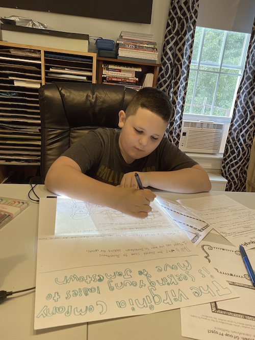 young boy homeschooling with project at table